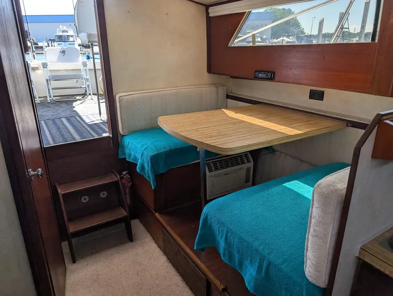 Slide: The Image of Interior of a 1977 Trojan F30 Express boat with dining area and window view. - 31