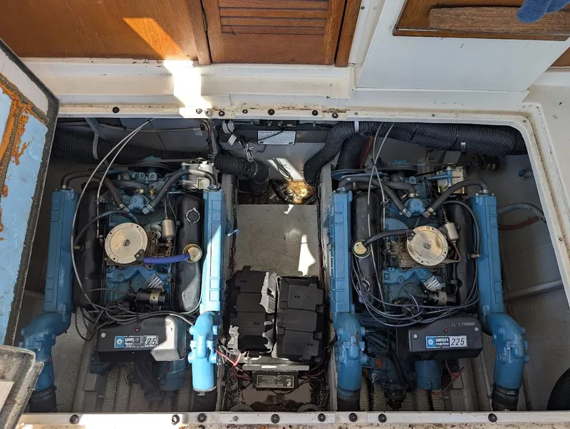 Slide: The Image of Engine compartment of a 1977 Trojan F30 Express boat, featuring dual marine engines. - 38