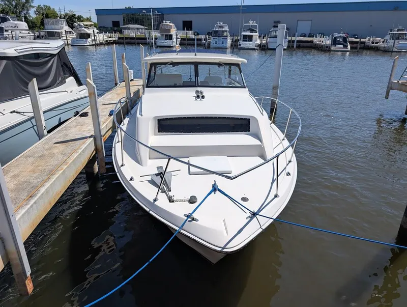 Slide: The Image of 1977 Trojan F30 Express boat docked at a marina, surrounded by other vessels. - 5