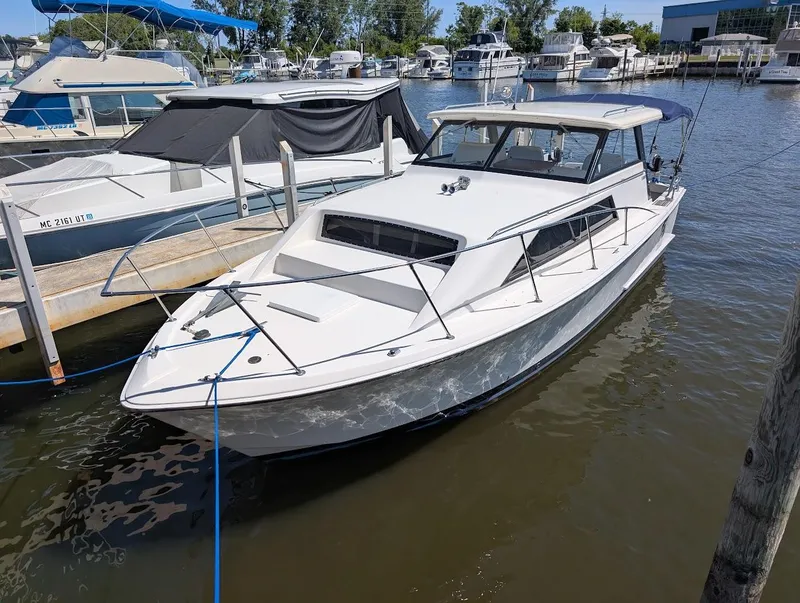 Slide: The Image of 1977 Trojan F30 Express boat docked at a marina, surrounded by other vessels. - 6