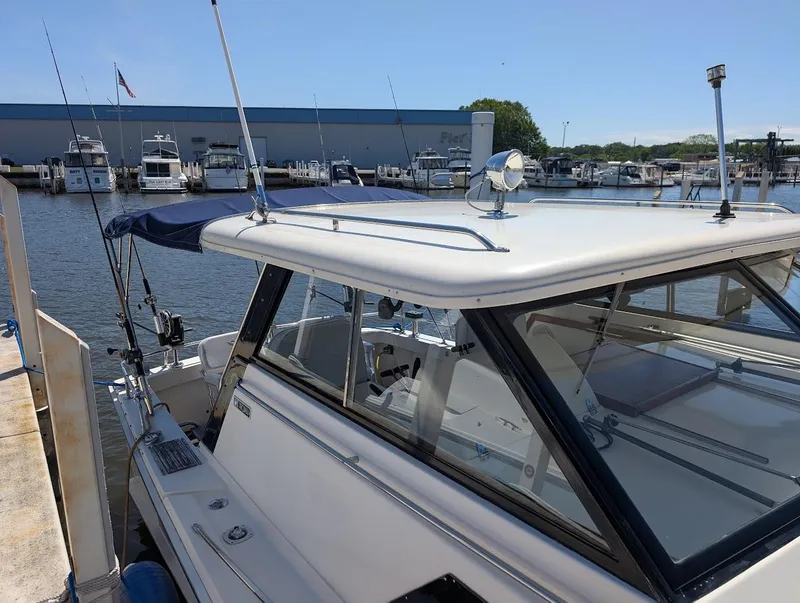 Slide: The Image of 1977 Trojan F30 Express boat docked at marina, clear day, blue canopy. - 9