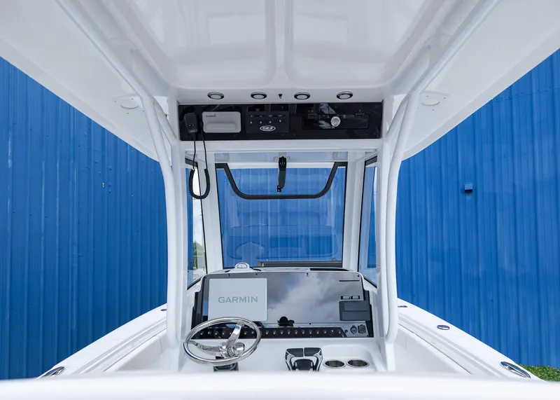 Slide: The Image of 2026 Sea Hunt Gamefish 27 Coffin Box helm with Garmin display, blue background. - 15