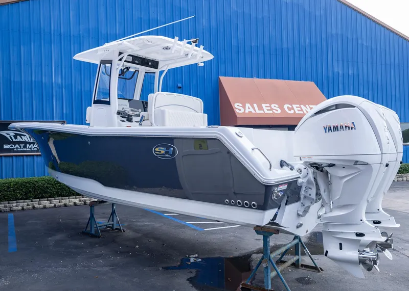 Slide: The Image of 2026 Sea Hunt Gamefish 27 Coffin Box boat displayed at sales center with Yamaha engine. - 2
