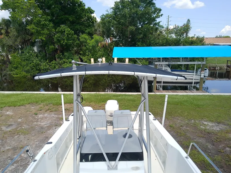 Slide: The Image of 2000 Hydra-Sports 212 Seahorse CC boat with T-top, docked near lush greenery. - 13