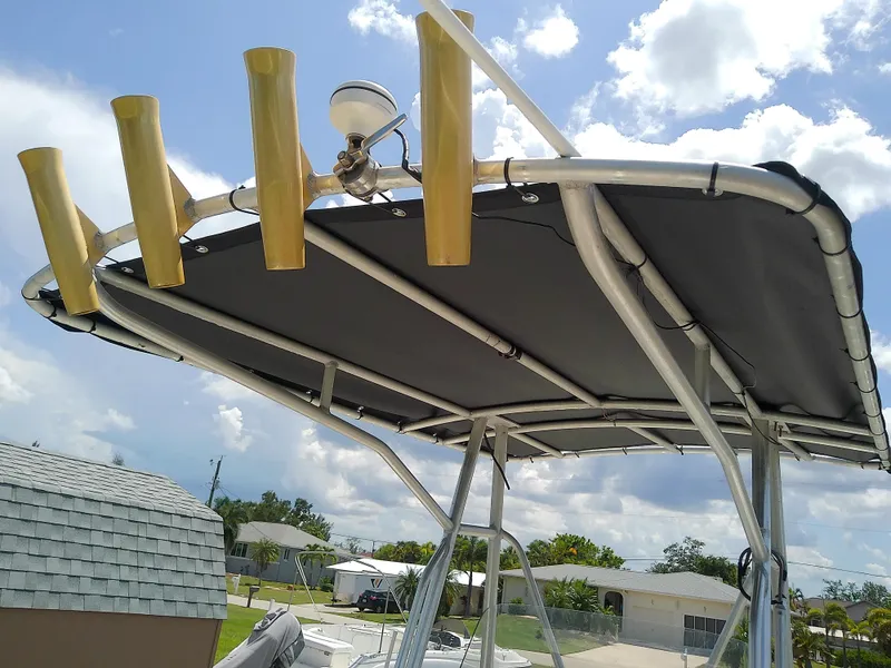 Slide: The Image of T-top of 2000 Hydra-Sports 212 Seahorse CC with rod holders under a sunny sky. - 17