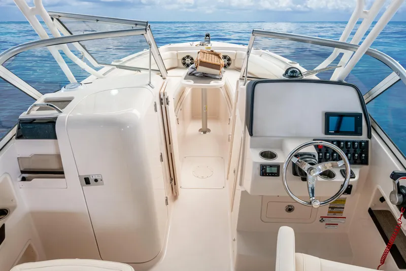 Slide: The Image of 2026 Grady-White GW 235 Freedom boat interior with steering wheel and ocean view. - 11
