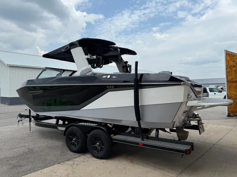 Slide: The Image of 2025 Nautique Super Air Nautique G23 boat on trailer, parked outdoors under cloudy sky. - 15