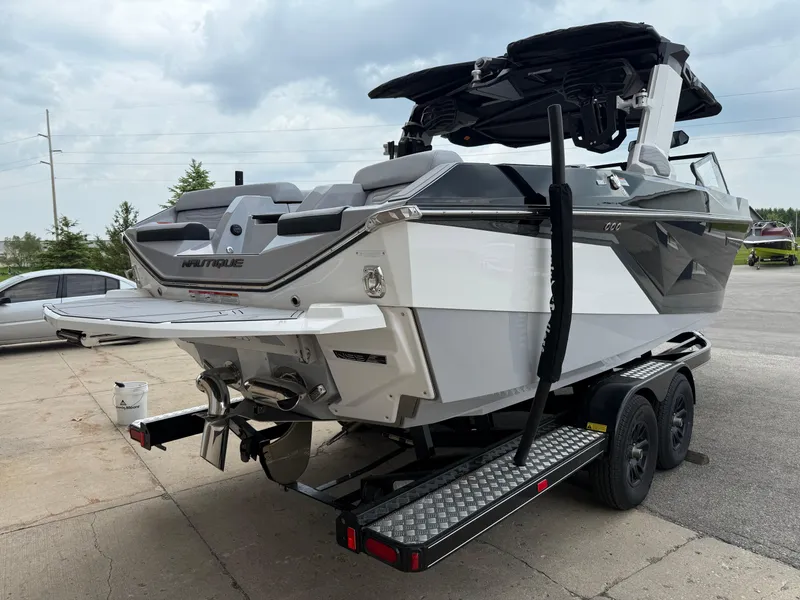 Slide: The Image of 2025 Nautique Super Air Nautique G23 boat on trailer, rear view, overcast sky. - 17