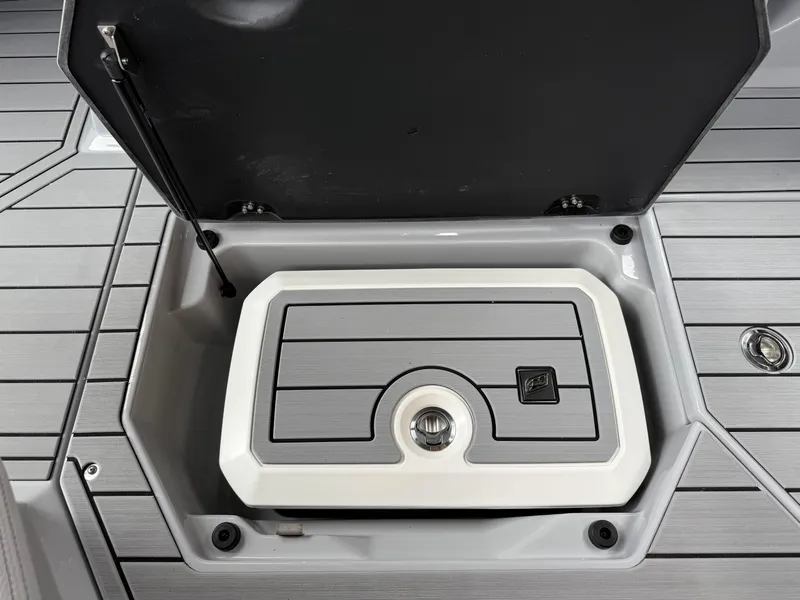Slide: The Image of 2025 Nautique Super Air Nautique G23 storage compartment with open lid, showcasing sleek design. - 42