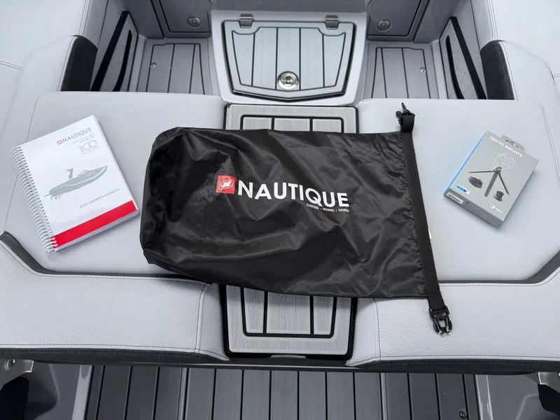 Slide: The Image of 2025 Nautique Super Air Nautique G23 accessories: owner's manual, branded bag, and tripod mounts. - 44