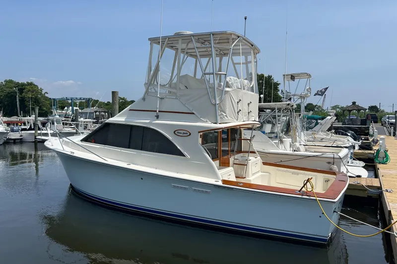 Slide: The Image of 1989 Ocean Yachts Super Sport docked at marina, featuring classic design and spacious deck. - 0