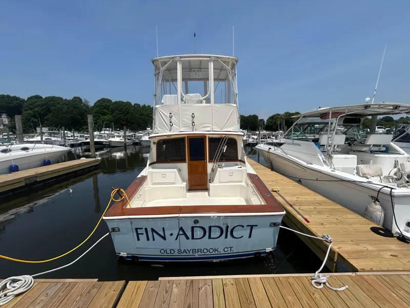 Slide: The Image of 1989 Ocean Yachts Super Sport docked at marina, labeled "Fin Addict," Old Saybrook, CT. - 1
