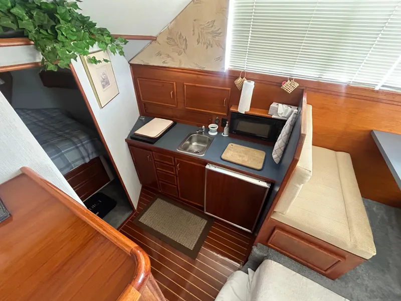 Slide: The Image of 1989 Ocean Yachts Super Sport interior with kitchenette, sink, microwave, and seating area. - 10