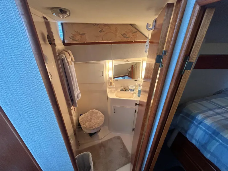 Slide: The Image of 1989 Ocean Yachts Super Sport bathroom with sink, toilet, and mirror. Cozy marine interior. - 12