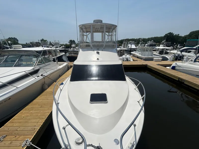 Slide: The Image of 1989 Ocean Yachts Super Sport docked at marina, surrounded by other boats. - 2