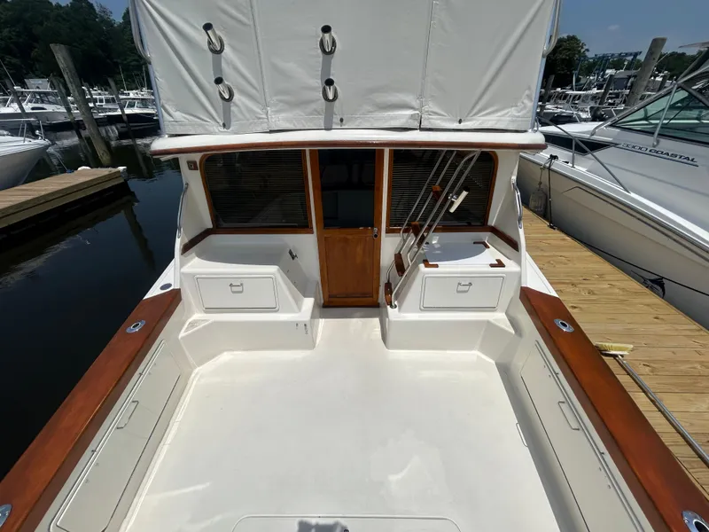Slide: The Image of 1989 Ocean Yachts Super Sport boat deck with wooden accents, docked at marina. - 5