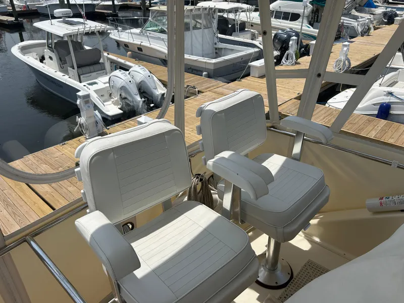 Slide: The Image of 1989 Ocean Yachts Super Sport boat interior with white captain chairs at marina. - 6