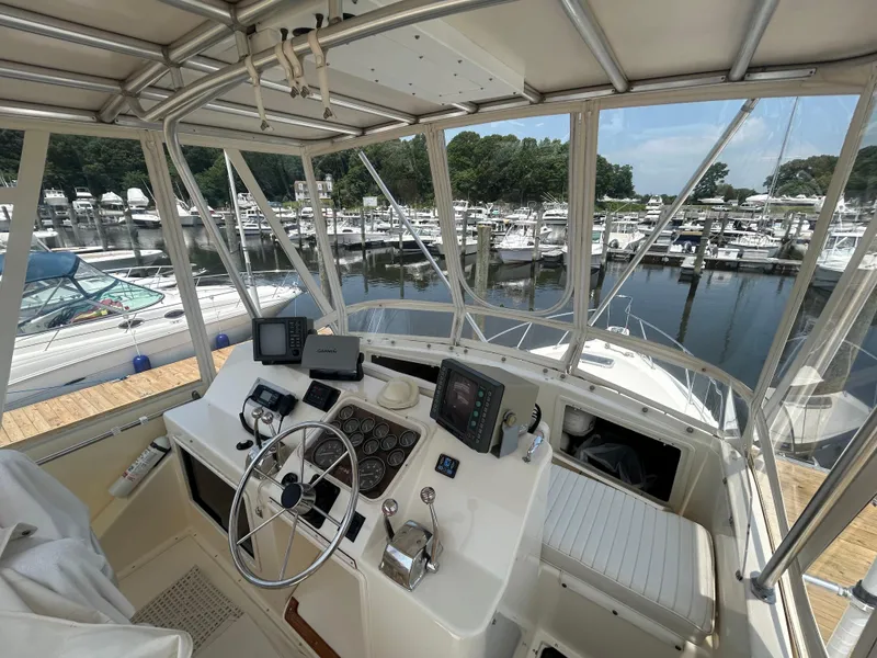 Slide: The Image of 1989 Ocean Yachts Super Sport cockpit with marina view, featuring navigation equipment and controls. - 7