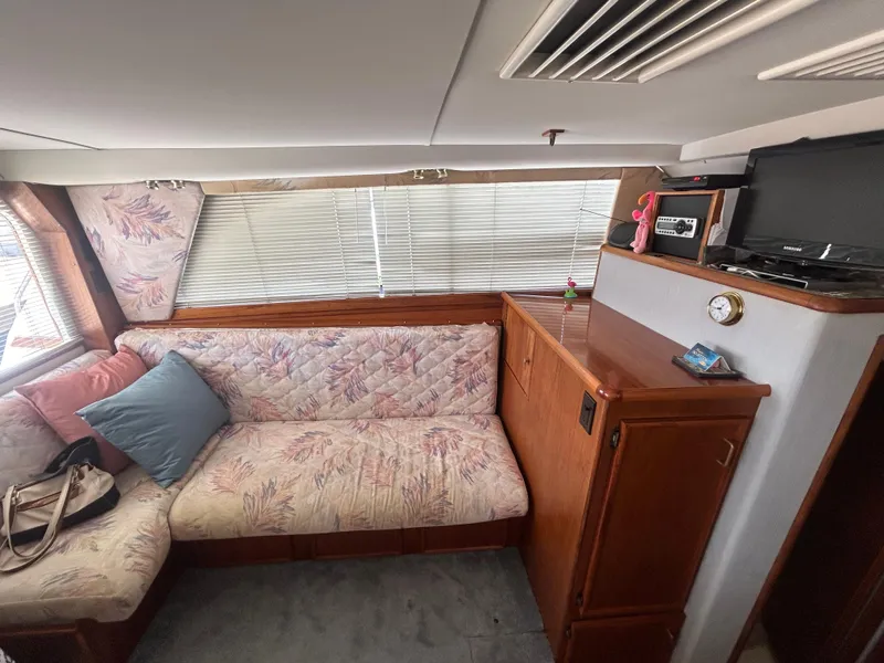 Slide: The Image of Interior of 1989 Ocean Yachts Super Sport with floral sofa, TV, and wooden cabinetry. - 9