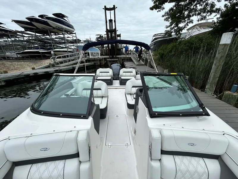 Slide: The Image of 2026 Regal LX4 boat docked, featuring sleek white seating and dual windshields. - 11