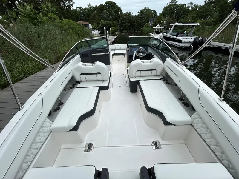 Slide: The Image of 2026 Regal LX4 boat interior with white seating, docked near lush greenery. - 4