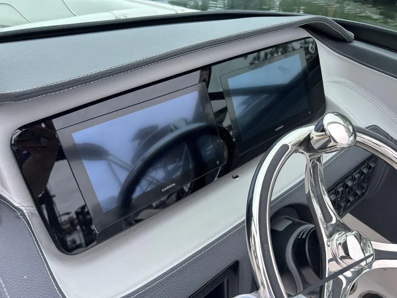 Slide: The Image of 2026 Regal LX4 boat dashboard with dual Garmin displays and sleek steering wheel. - 6