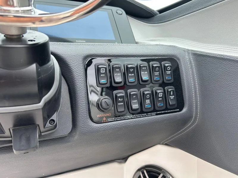 Slide: The Image of Control panel of 2026 Regal LX4 boat with various switches and steering wheel. - 7