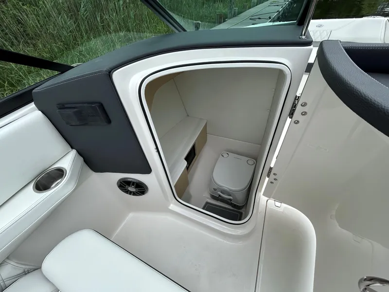 Slide: The Image of 2026 Regal LX4 boat interior with compact toilet and seating area. - 8