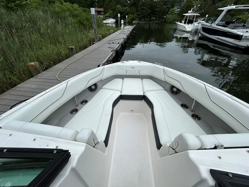 Slide: The Image of 2026 Regal LX4 boat interior with white seating, docked by a wooden pier. - 9