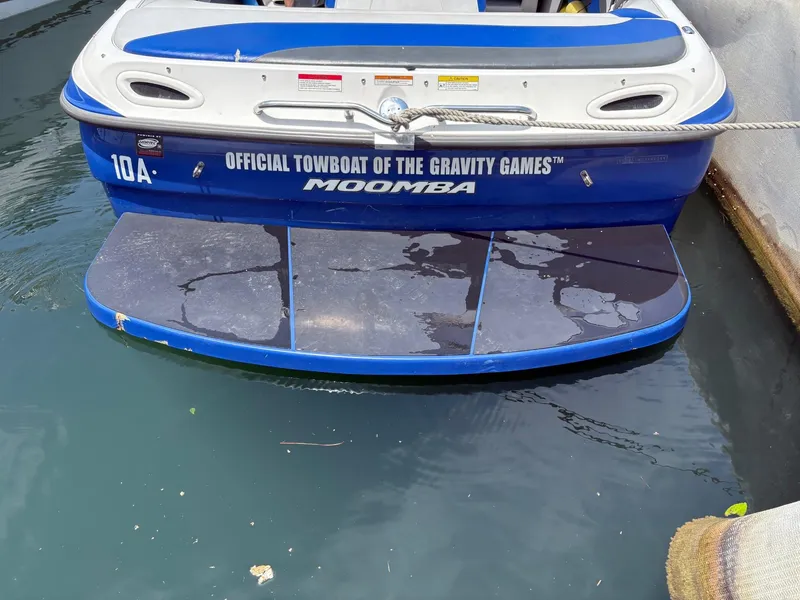 Slide: The Image of 2004 Moomba MOMBIUS LS boat, blue and white, docked on water, official towboat of Gravity Games. - 13