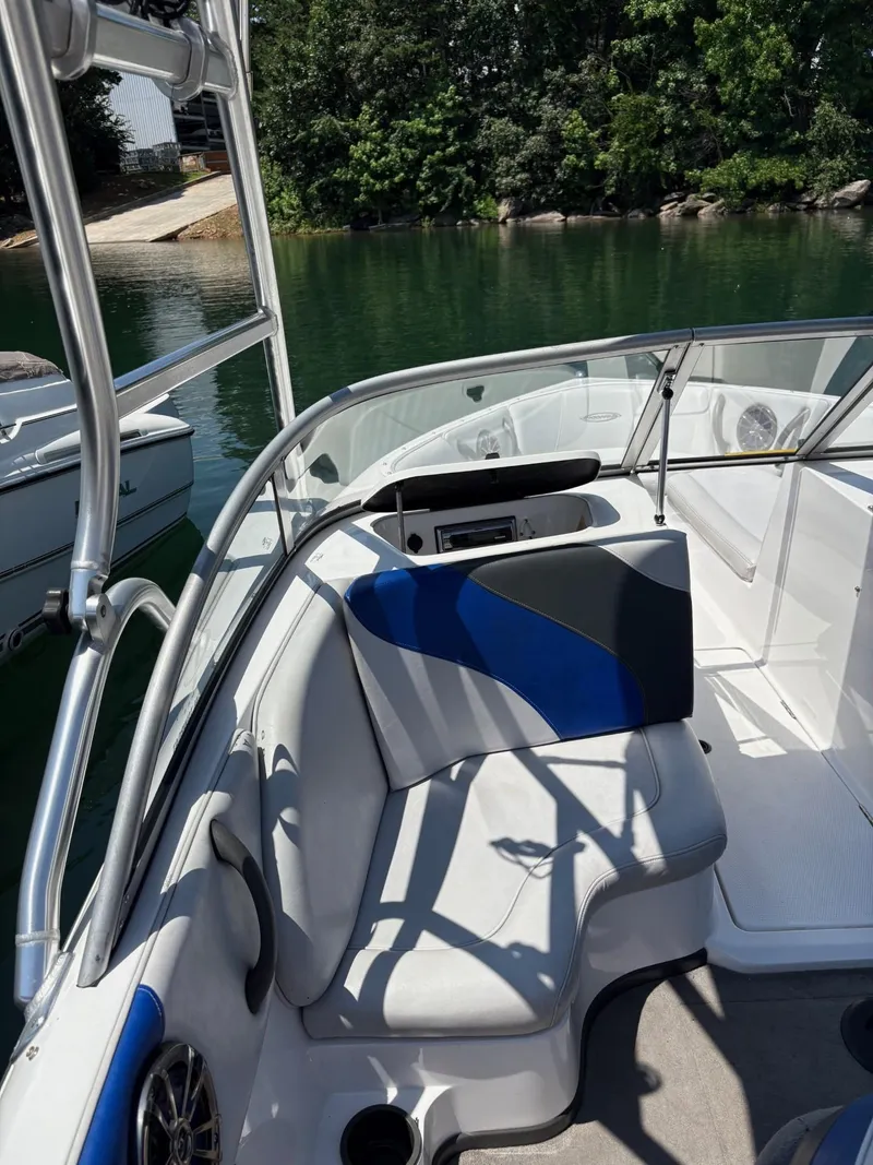 Slide: The Image of 2004 Moomba MOMBIUS LS boat interior with blue and gray seating, docked by a lake. - 16