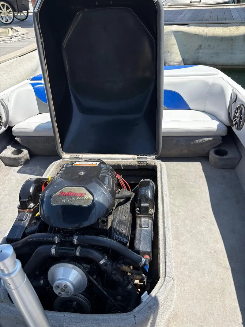 Slide: The Image of 2004 Moomba MOBIUS LS boat engine compartment with Indmar engine, open cover, and seating area. - 17