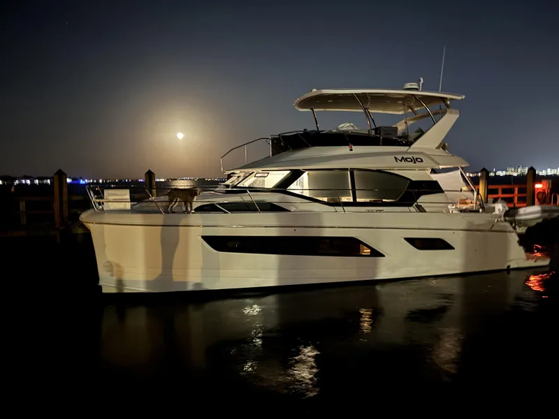 Slide: The Image of Aquila 44 Yacht 2020 docked at night with moonlit reflections on water. - 10