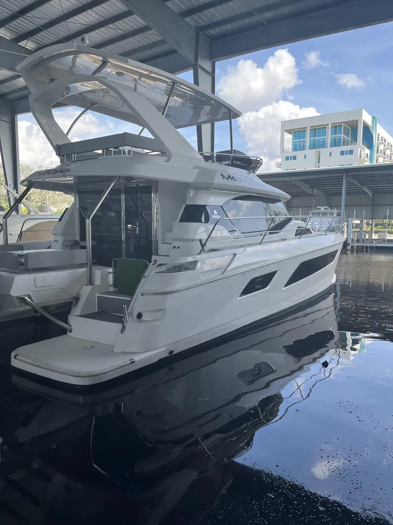 Slide: The Image of 2020 Aquila 44 Yacht docked in a covered marina, reflecting on calm water. - 3