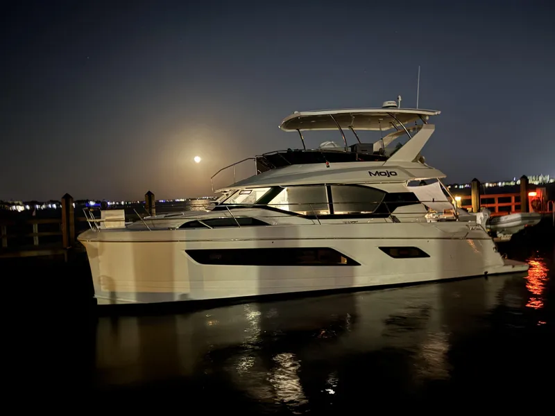 Slide: The Image of 2020 Aquila 44 Yacht docked at night with moonlit reflections. - 7