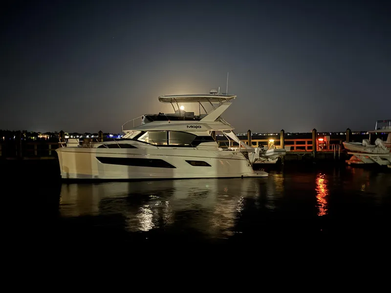 Slide: The Image of Aquila 44 Yacht 2020 docked at night, reflecting on calm water. - 8