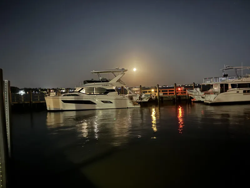 Slide: The Image of Aquila 44 Yacht 2020 docked at night with moonlit reflections on water. - 9