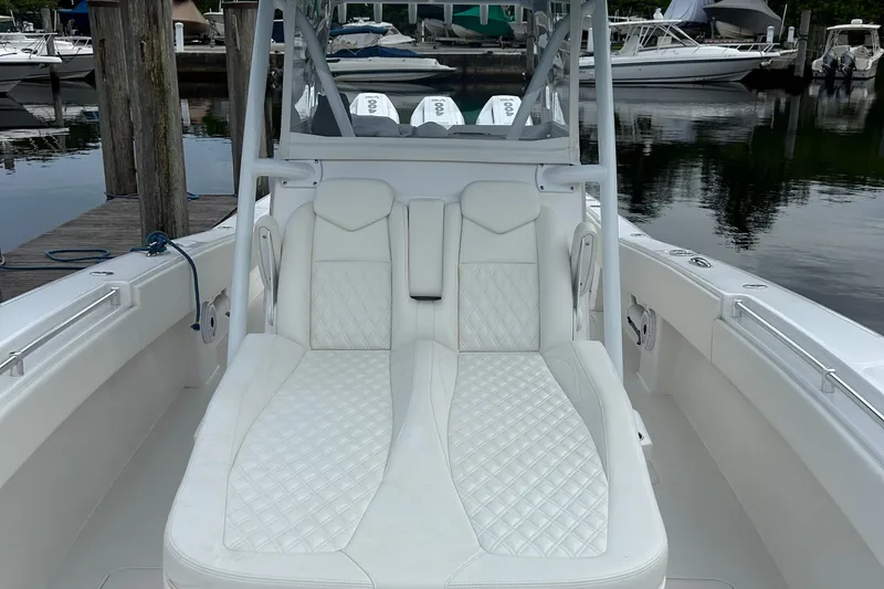 Slide: The Image of 2023 Invincible 36 Open Fisherman boat with white cushioned seating at a marina. - 4