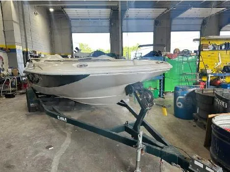 The Image of 2000 Harris-Kayot Star 22V O/B boat in a garage workshop setting. - 1