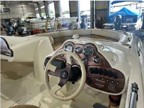 Slide: The Image of 2000 Harris-Kayot Star 22V O/B boat dashboard with steering wheel and gauges in a workshop. - 3