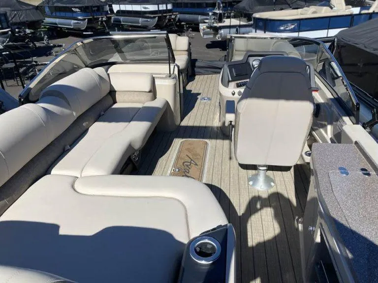 Slide: The Image of 2023 Avalon Catalina 2585 VRBW boat interior with plush seating and modern dashboard. - 4