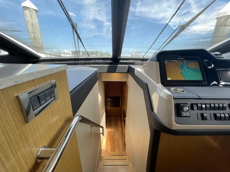Slide: The Image of Interior view of 2017 Sea Ray L590 Fly yacht with navigation system and wooden stairs. - 19