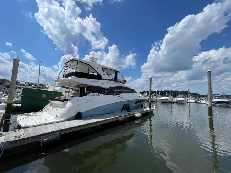 Slide: The Image of 2017 Sea Ray L590 Fly yacht docked at marina under blue sky. - 2