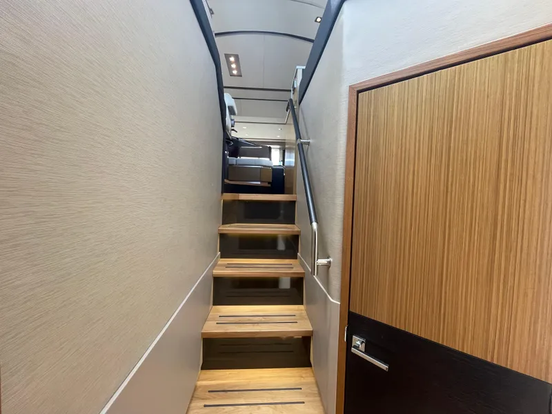 Slide: The Image of Staircase inside 2017 Sea Ray L590 Fly yacht, featuring modern wood and metal design. - 20