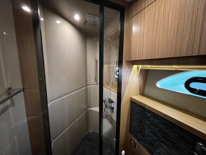 Slide: The Image of Luxurious bathroom interior of 2017 Sea Ray L590 Fly yacht with modern shower and wood accents. - 24