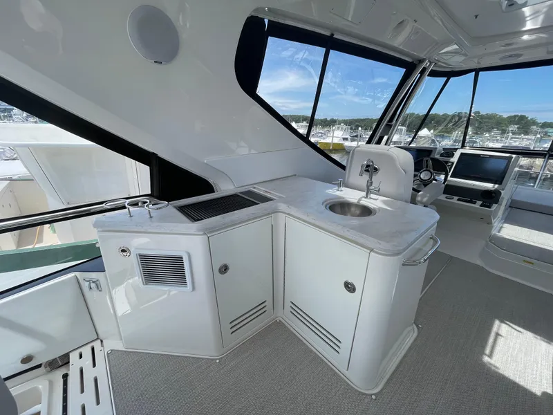 Slide: The Image of 2017 Sea Ray L590 Fly yacht interior with sleek kitchenette and modern helm station. - 40