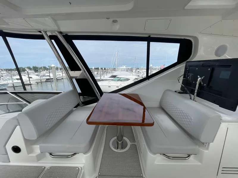Slide: The Image of 2017 Sea Ray L590 Fly yacht interior with seating and table, overlooking marina. - 44