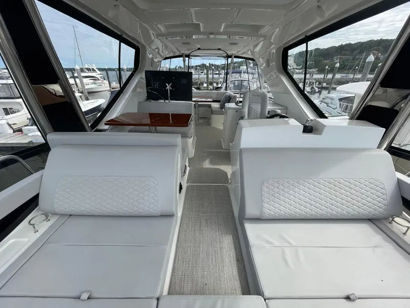 Slide: The Image of Luxurious interior of 2017 Sea Ray L590 Fly yacht with white seating and panoramic windows. - 46