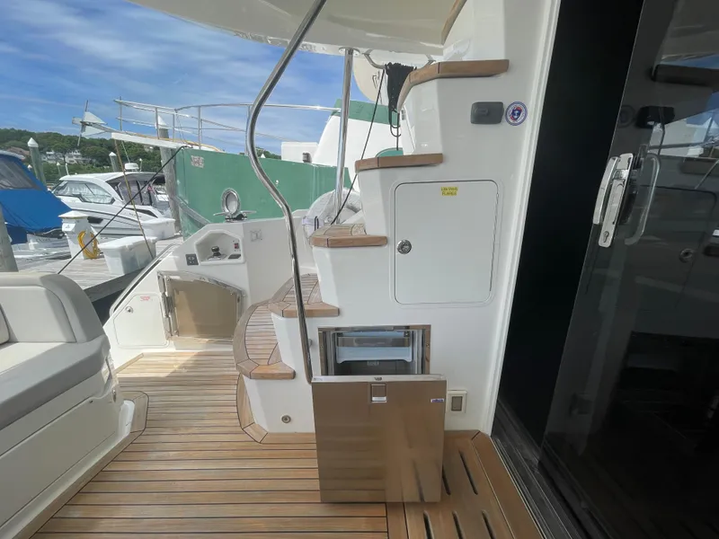 Slide: The Image of 2017 Sea Ray L590 Fly yacht deck with wooden flooring and staircase. - 6