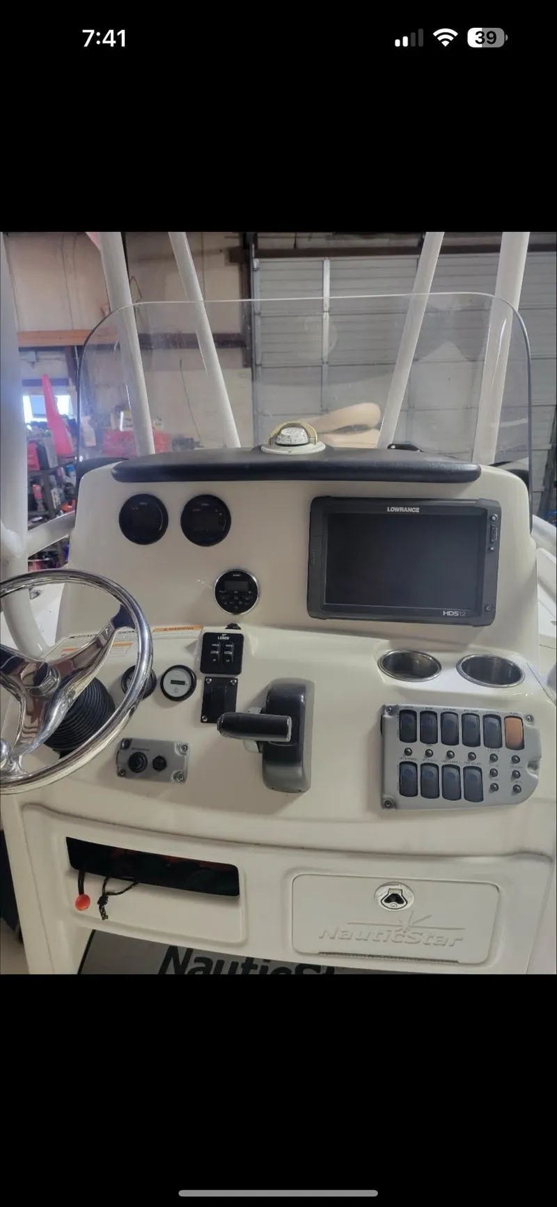 Slide: The Image of 2014 NauticStar 244 XTS boat dashboard with steering wheel and control panel. - 3